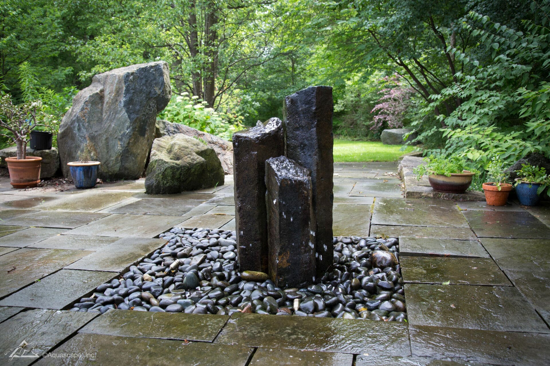Mongolian basalt column fountainscape on a bluestone patio built by Garden State Koi